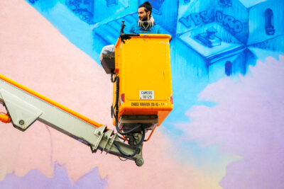 Personne qui peint une fresque colorée sur un mur - Agrandir l'image 3 sur 10, fenêtre modale