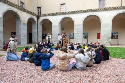 Les enfants assis, répètent la chorégraphie avec les animateurs, la co-directrice et la chorégraphe au coeur de l'abbaye - Agrandir l'image 3 sur 5, fenêtre modale