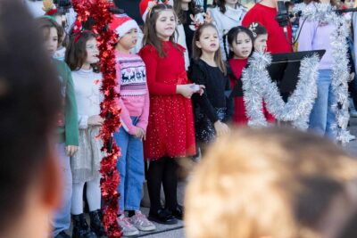 Les enfants chantent, en tenue de Noël sous la direction de leur enseignante - Agrandir l'image 2 sur 5, fenêtre modale