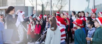 Les enfants chantent, en tenue de Noël sous la direction de leur enseignante