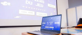 Ordinateur et vidéoprojecteur affichant l'affiche "métiers du jeu"