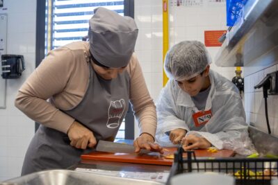 Une mère et son fils en train de couper méticuleusement l'agrume  - Agrandir l'image 1 sur 7, fenêtre modale