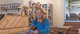 Prescilia Traisnel dans son café, livre à la main