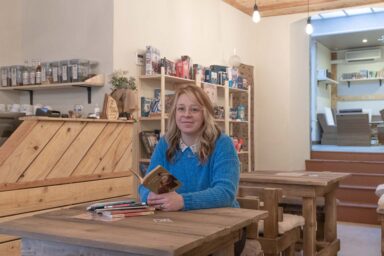 Prescilia Traisnel dans son café, livre à la main