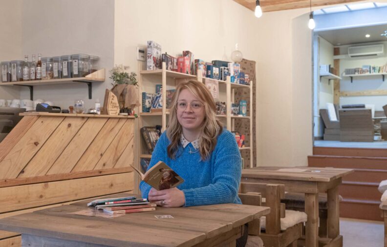 Prescilia Traisnel dans son café, livre à la main